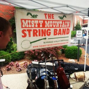 Misty Mountain String Band's banner design on display at a show.